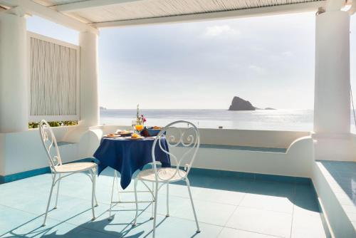 a table and chairs on a balcony with the ocean at Eunymos Panarea in Panarea