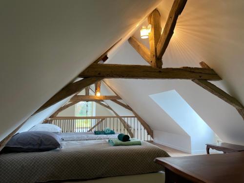 a bedroom with a bed in the attic at Fermette et Ecuries Tourangelles in Bréhémont
