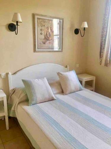 une chambre avec un lit avec deux oreillers dessus dans l'établissement Villa de Charme 60 m2 Piscines Tennis Loisirs Inclus Residence Premiun Pierre et Vacances Les Restanques du Golfe de Saint Tropez, à Grimaud