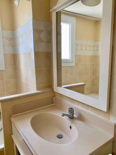 une salle de bain avec un lavabo et un miroir dans l'établissement Villa de Charme 60 m2 Piscines Tennis Loisirs Inclus Residence Premiun Pierre et Vacances Les Restanques du Golfe de Saint Tropez, à Grimaud