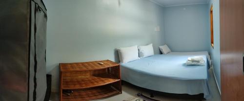 une petite chambre avec un lit et une table dans l'établissement Casa do Mar, à Salvador