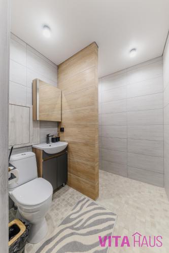 a bathroom with a toilet and a sink at Фирменные апартаменты от Vita Haus Beverly in Petropavlovsk