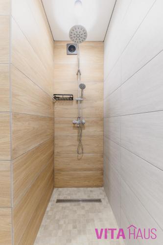a bathroom with a shower with wooden walls at Фирменные апартаменты от Vita Haus Beverly in Petropavlovsk