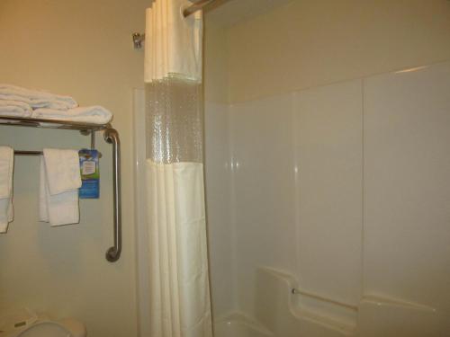 a bathroom with a shower with a shower curtain at Baymont by Wyndham Columbia Fort Jackson in Columbia