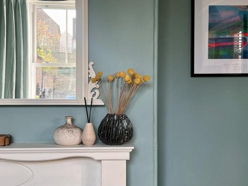 a vase sitting on a mantle with two vases at Stylish Victorian Home - Central Frome in Frome