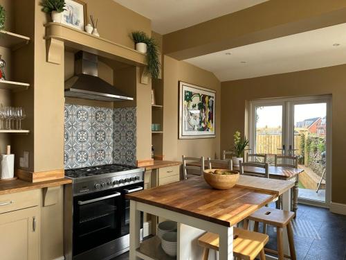 a kitchen with a wooden table and a stove at Stylish Victorian Home - Central Frome in Frome