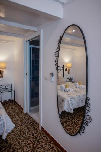 a mirror on a wall in a bedroom with a bed at Eunymos Panarea in Panarea