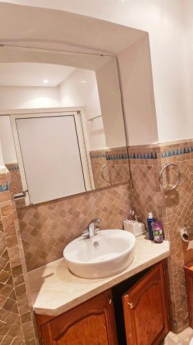 a bathroom with a sink and a mirror at Beautiful cozy apartment with pool in Marrakesh
