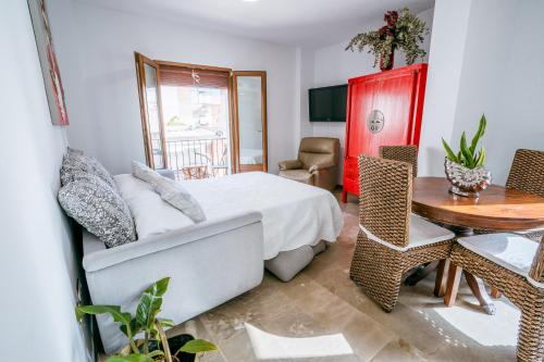 a bedroom with a bed and a desk and a table at Apartamentos El Tranco del Mar in Almuñécar