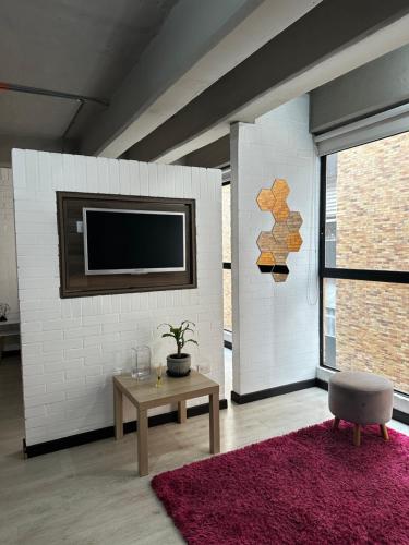 a living room with a tv on a white brick wall at Apartamento en Chapinero in Bogotá
