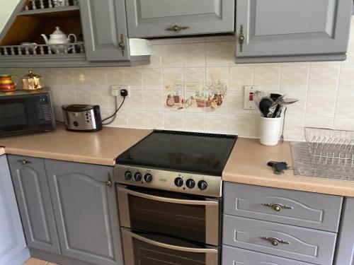 a kitchen with a stove top oven in a kitchen at 4 bedroom, 7 single beds, with free parking & wifi near new walkway in Navan