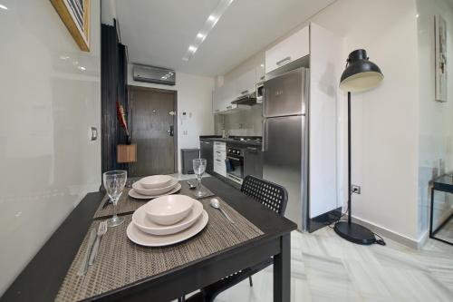 a kitchen with a table with plates and wine glasses at La Siesta Beach Resort in Mohammedia