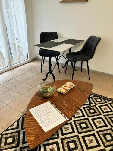 a table with a bowl of food and two chairs at Le Studio in Commercy