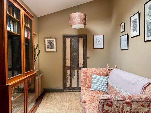 a living room with a couch and a television at Little Hideaway - Central Frome in Frome