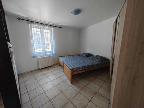 une petite chambre avec un lit et une fenêtre dans l'établissement Chez Lili et Roger, à Schiltigheim
