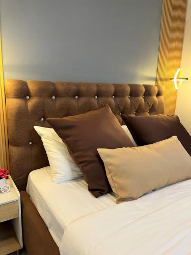 a bed with a brown headboard and some pillows at I - scape in Subic