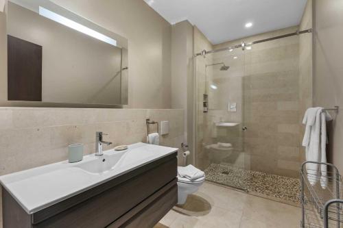 a bathroom with a sink and a toilet and a shower at Eagle Beach - Garden Breeze 1BR condo - LV101 in Palm-Eagle Beach