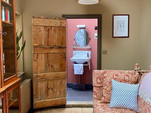 a bathroom with a wooden door and a sink at Little Hideaway - Central Frome in Frome