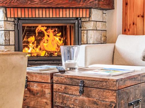 a living room with a fireplace and a table with a glass at Chalet Chalet Soleil by Interhome in Nendaz