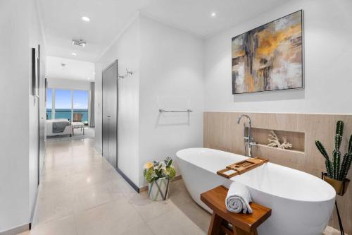 a white bathroom with a tub in a room at Beach View - Chic View Penthouse 3BR condo - LV603 in Palm-Eagle Beach