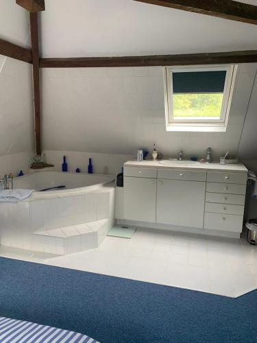 une salle de bain blanche avec une baignoire et un lavabo dans l'établissement Longère normande avec grand jardin, à Saint-Riquier-ès-Plains