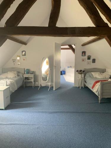 - une chambre mansardée avec 2 lits et un miroir dans l'établissement Longère normande avec grand jardin, à Saint-Riquier-ès-Plains
