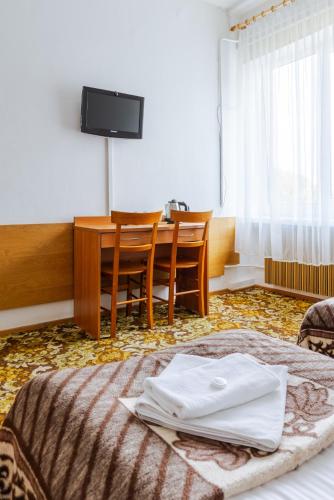 a hotel room with a table and a bed and a desk at Hotel Dom Marynarza in Gdynia