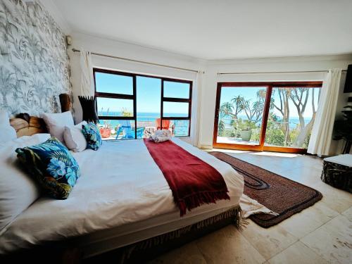 a bedroom with a large bed with a view of the ocean at Beachwood Camps Bay in Cape Town