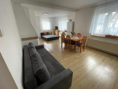 a living room with a couch and a table at Apartmán POD KOSTELEM in Nové Hamry