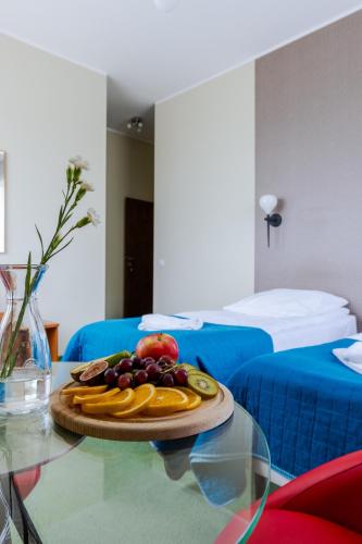 a plate of fruit on a glass table in a room at Hotel Dom Marynarza in Gdynia
