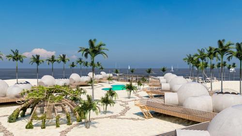 a resort with a beach with palm trees and chairs at Eden Bubbles Camp in Ras Sedr