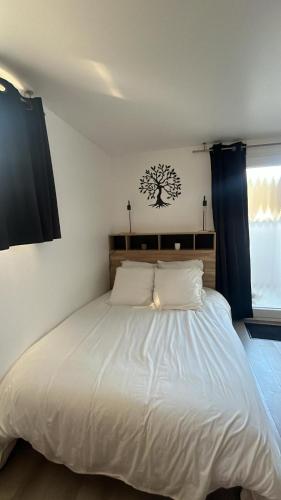 - une chambre avec un grand lit blanc et des rideaux bleus dans l'établissement Studio aux pieds des vignes, à Eguisheim