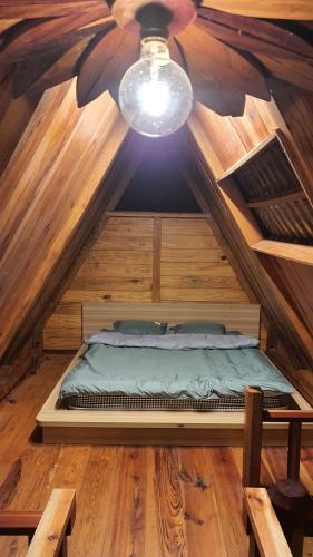 a bed in a wooden room with a ceiling at tropical garden homestay in Lien Khuong Airport