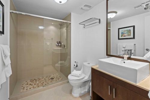 a bathroom with a shower and a toilet and a sink at Beachfront - Royal Penthouse 3BR condo - BC352 in Palm-Eagle Beach