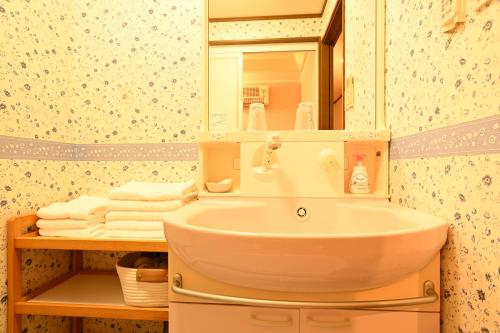a bathroom with a sink and a mirror and towels at Peace & Harmony 1 in Nagoya