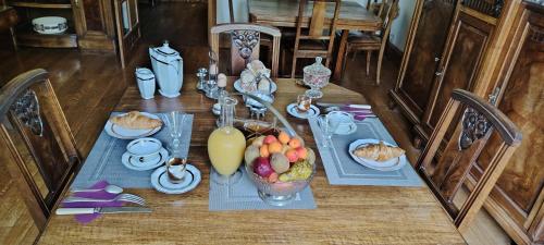 einen Tisch mit Essen und eine Schale Obst darauf in der Unterkunft La Passagere in Hauterive