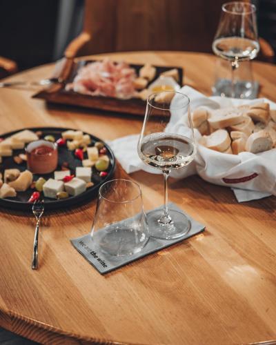 a table with glasses of wine and a plate of food at Scheiblhofer The Resort in Andau