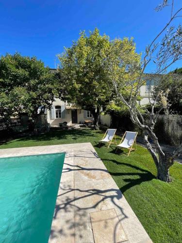 une cour avec deux chaises et une piscine dans l'établissement Couvent d'Aubignan - Maison de caractère & piscine, à Aubignan
