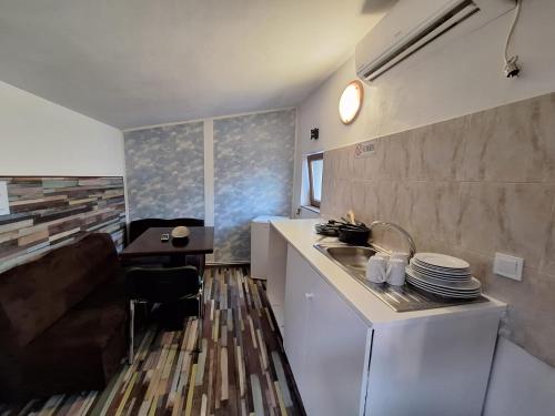 a kitchen with a sink and a table with plates at Vila Ris Piata Romana in Bucharest