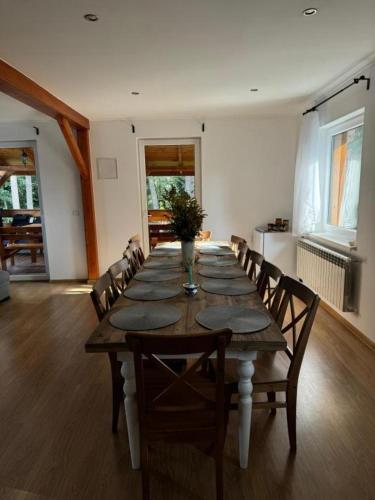 a long wooden table with chairs in a room at Nad Strumykiem in Koszele