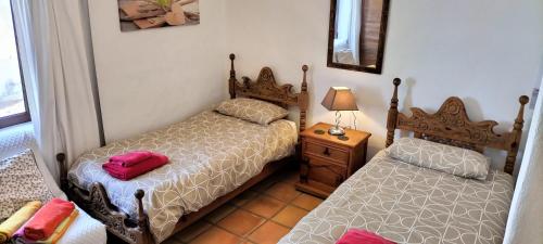 ティアスにあるCasa Maja, luxury villa, large heated pool, aircon, all bedrooms en-suiteのベッドルーム1室(ベッド2台、ランプ付きテーブル付)