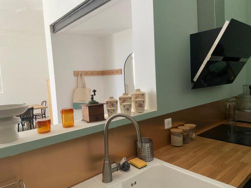 - un comptoir de cuisine avec un évier et un miroir dans l'établissement Couvent d'Aubignan - Maison de caractère & piscine, à Aubignan