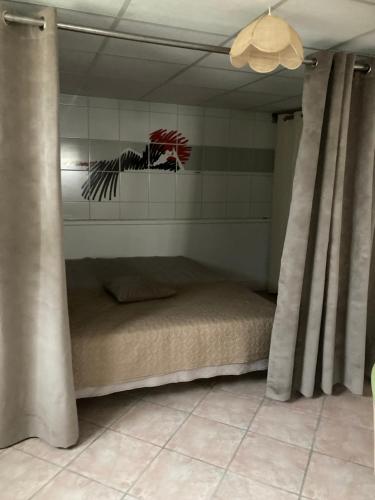 Ce lit se trouve dans un dortoir doté de rideaux et d'un plafond. dans l'établissement Proche pôle européen du cheval, à Champagné