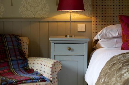 a bedroom with a bed and a lamp and a chair at Pear Tree Inn Whitley in Whitley