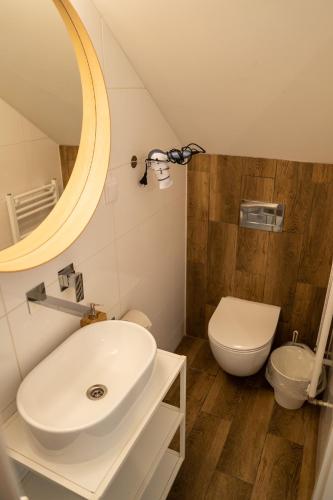 a bathroom with a white sink and a toilet at Zajazd w Biskupinie in Biskupin