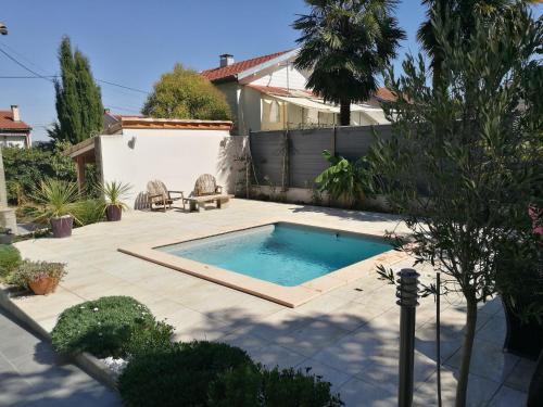 une piscine dans une cour avec une maison dans l'établissement Logis Soupetard, à Toulouse