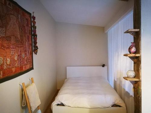 une petite chambre avec un lit et une fenêtre dans l'établissement Logis Soupetard, à Toulouse