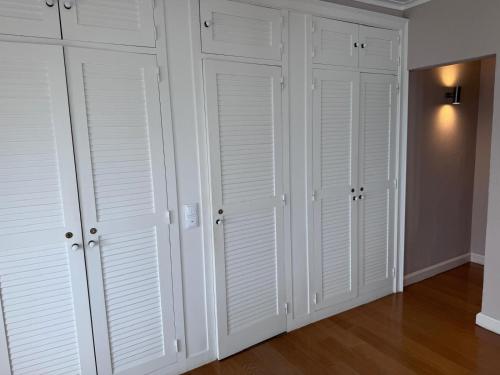 a room with white closet doors and wooden floors at Atlantic Views Sintra Guest House in Colares