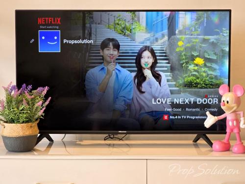 a tv screen with a picture of a couple brushing their teeth at Cozy Seaview Suite Johor Bahru CIQ in Johor Bahru