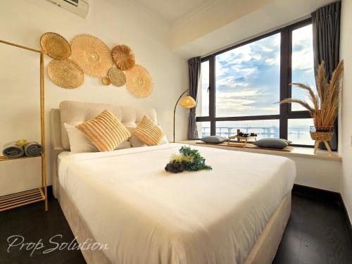a bedroom with a large white bed with a large window at Cozy Seaview Suite Johor Bahru CIQ in Johor Bahru